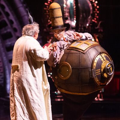 Man wears a metallic and round structure on his body that represents technological progress - Cirque du Soleil Kurios